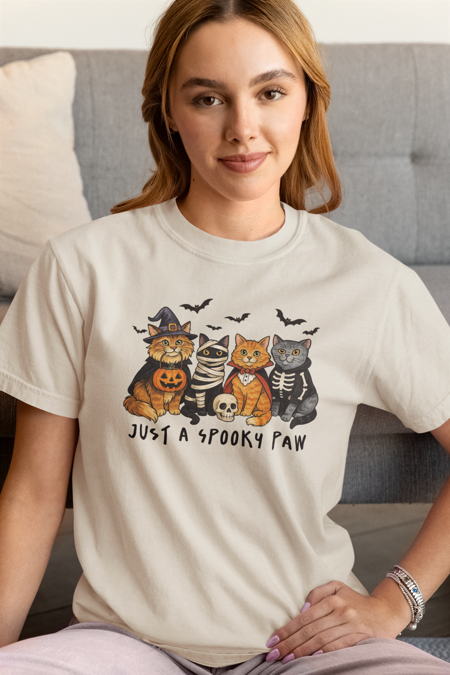 Model wearing Just a Spooky Paw Halloween Cat T-Shirt in beige color