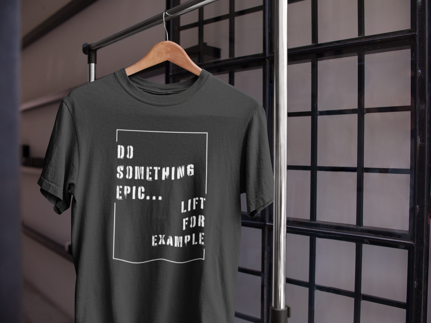 Black motivational gym t-shirt on hanger with "Do Something Epic – Lift For Example" design, ideal for lifting and fitness