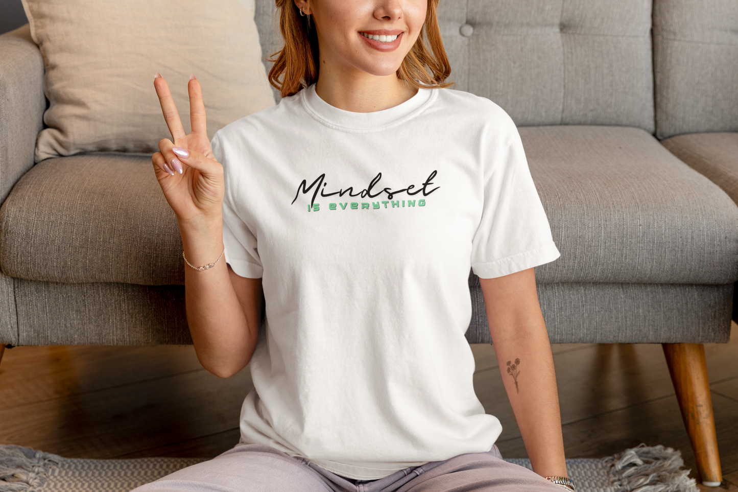 Woman sitting with white Mindset Is Everything T-Shirt – inspirational gym shirt.