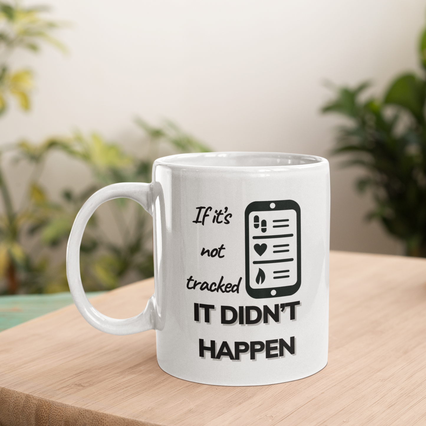 Motivational coffee mug with fitness tracking design placed on wooden surface with green plant in background