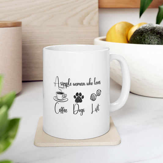 11oz ceramic mug with “A simple woman who loves coffee, dogs, lift” and icons of a coffee cup, paw print, and dumbbell – on kitchen counter