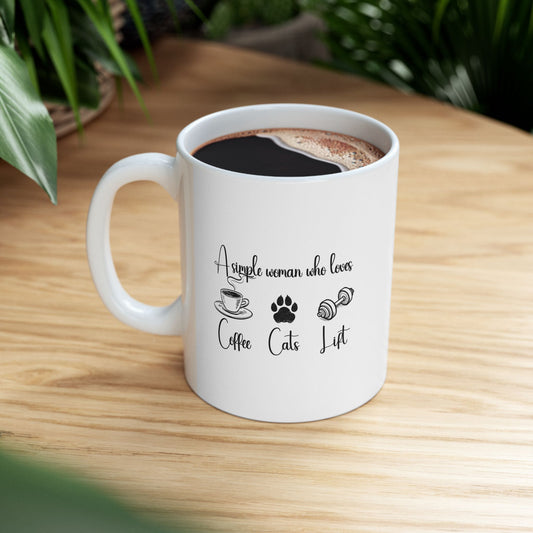 11oz ceramic mug with coffee, placed on a wooden table surrounded by greenery – features icons of coffee, cat paw, and dumbbell