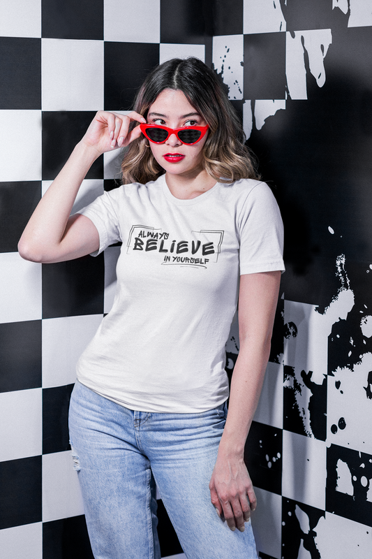 Woman wearing white “Always Believe In Yourself” T-shirt – seated, casual pose.
