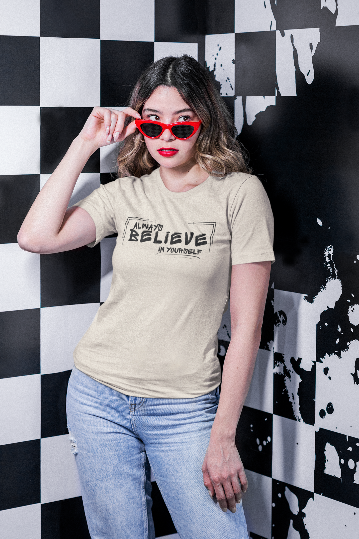 Woman wearing beige “Always Believe In Yourself” T-shirt – seated, casual pose.