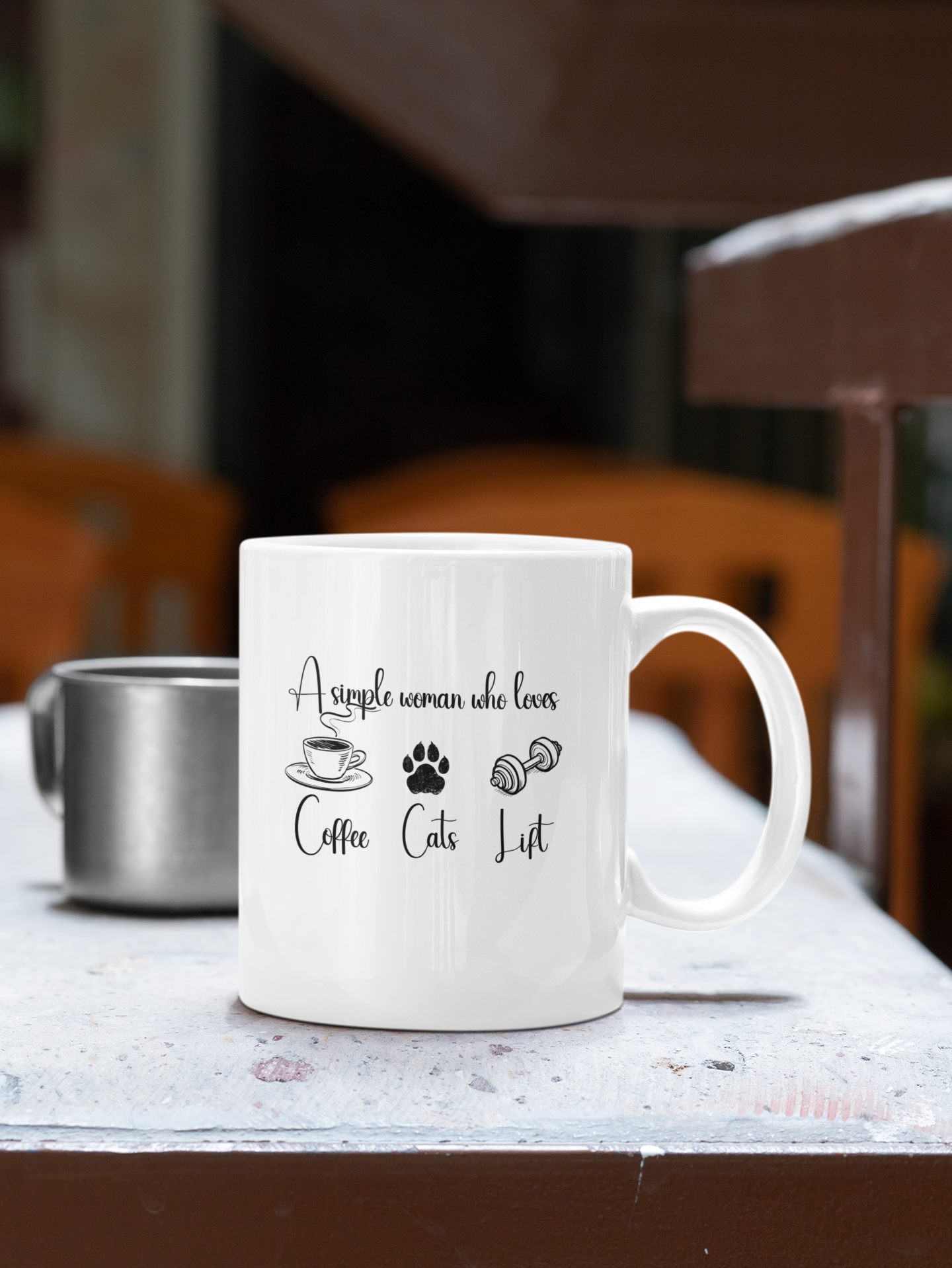 Person holding a white ceramic mug with the phrase “A simple woman who loves coffee, cats, lift” – cute fitness and cat lover gift idea