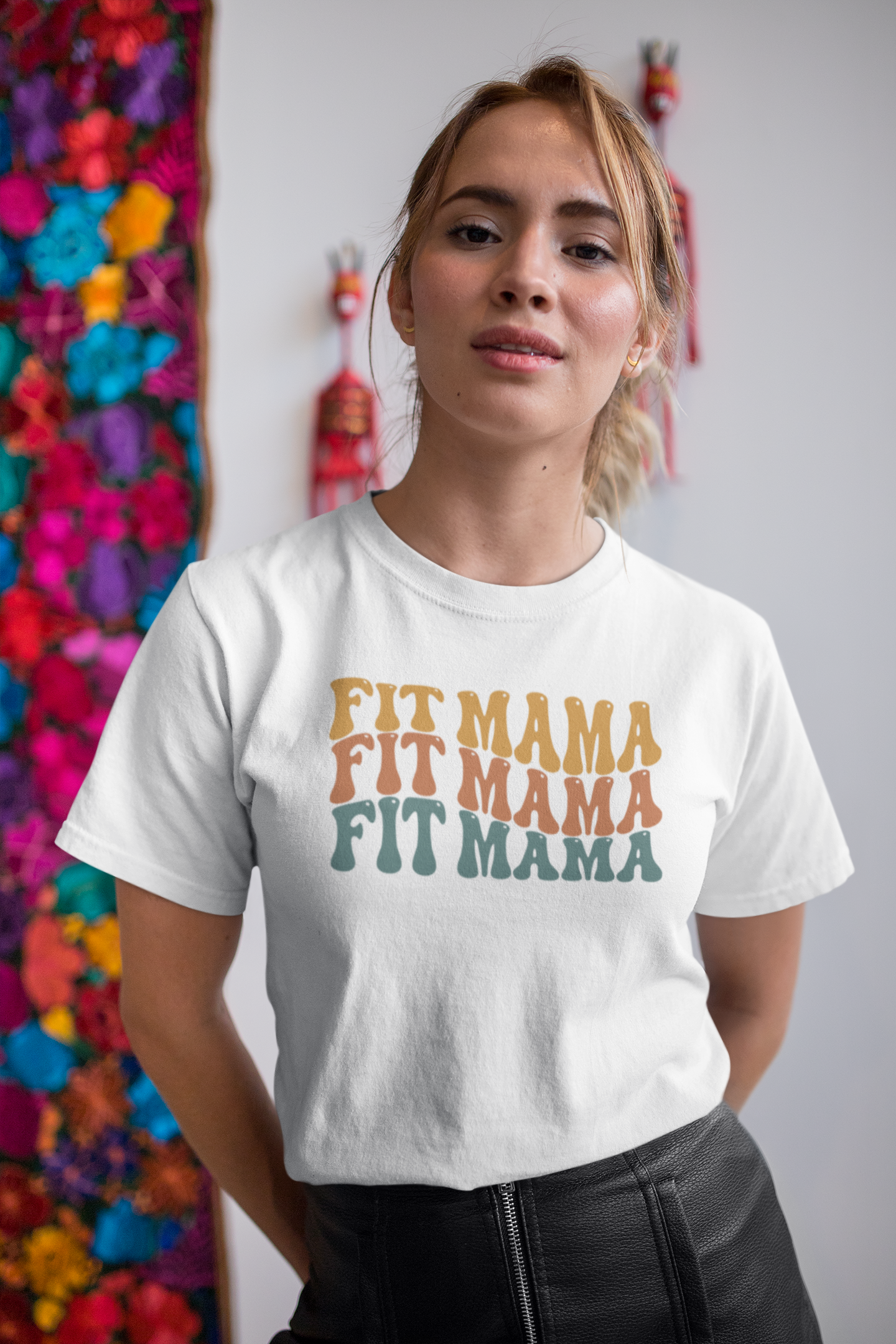 Woman wearing white Fit Mama t-shirt with retro colorful design – fitness mom style.