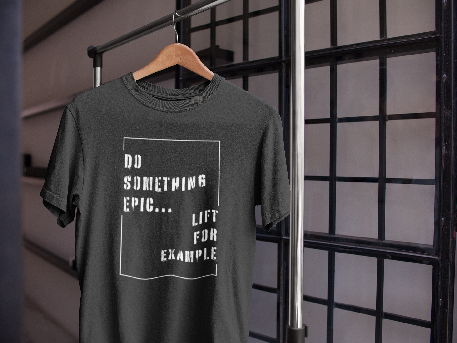 Black motivational gym t-shirt on hanger with "Do Something Epic – Lift For Example" design, ideal for lifting and fitness