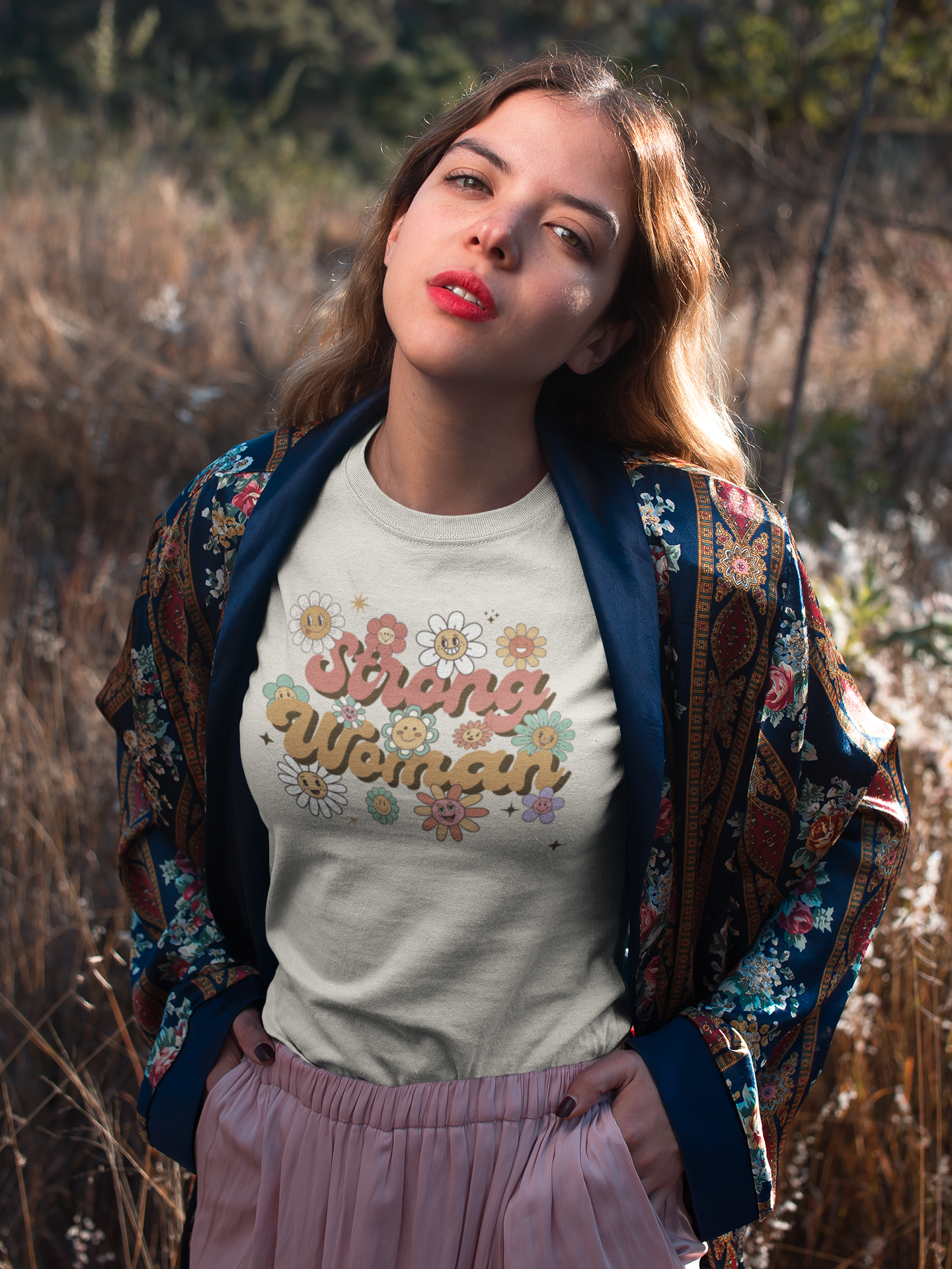 Woman in nature wearing white Strong Woman T-shirt – feminist floral graphic shirt