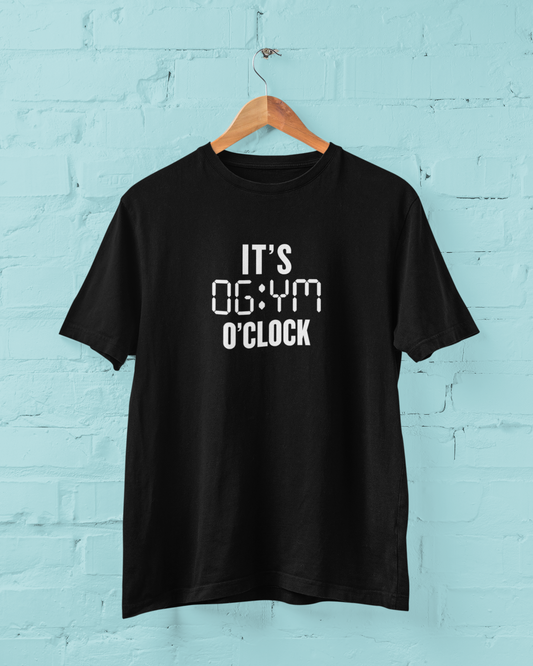 Black t-shirt with the phrase “It’s Gym O’Clock” hanging outdoors – unisex gym shirt for fitness lovers
